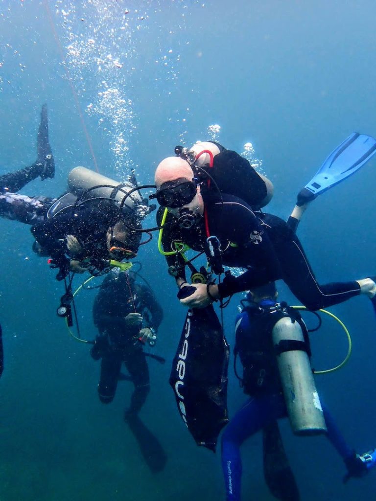 Divers Underwater Collecting Rubbish